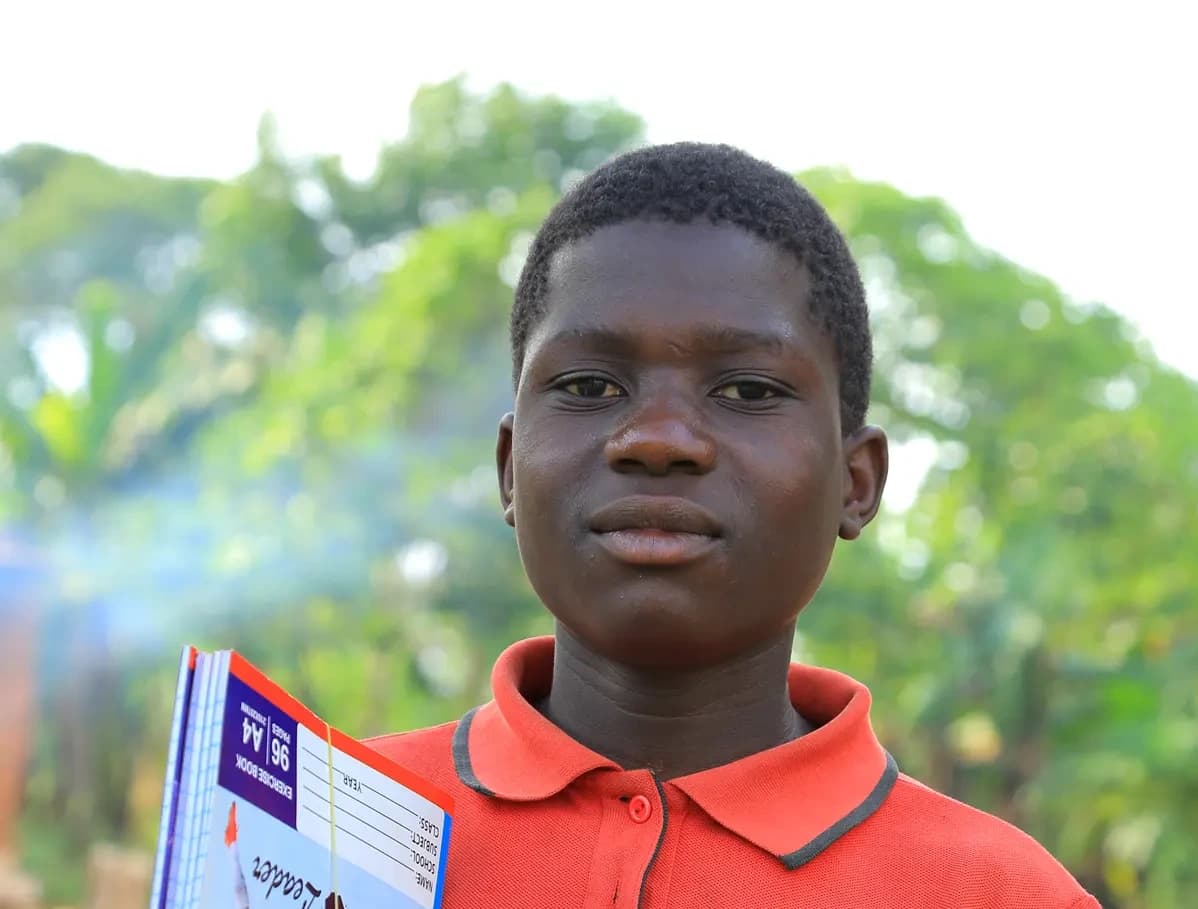 Innocent holding a stack of notebooks