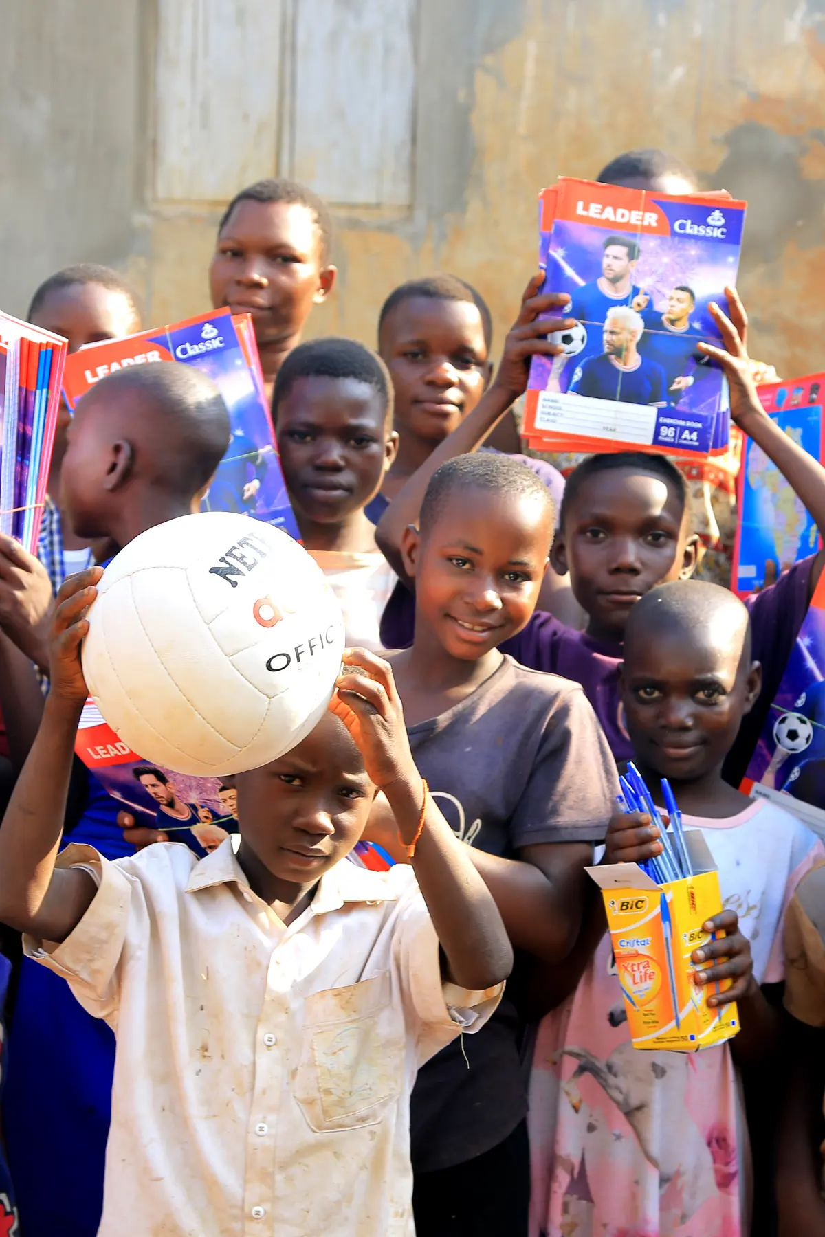Group of children with books and a soccer ball