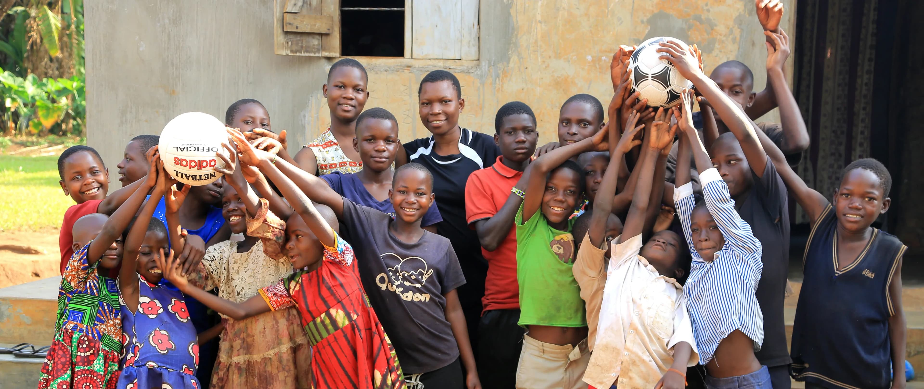 Children posing with a soccer ball